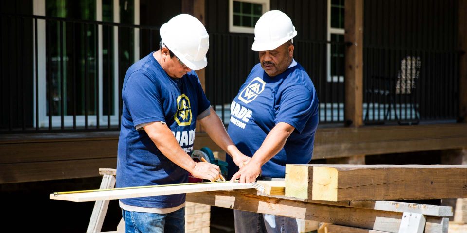Antonio Wade and a team member review measurements of a piece of wood while constructing a home in Rock Hill, SC.