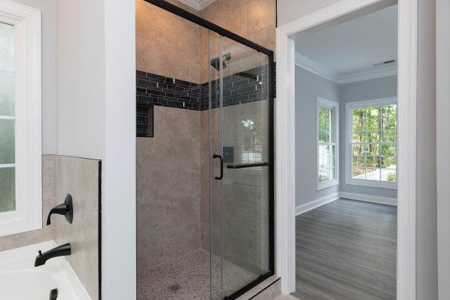 Bathroom remodel featuring glass framed shower and black fixtures designed and installed by Wade Construction of Rock Hill, SC