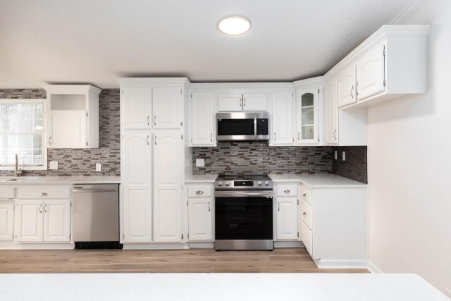 Newly remodeled kitchen with white cabinetry and flush mounted ceiling lights